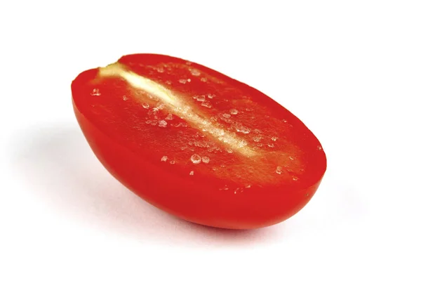 Closeup metade do tomate com sal encontra-se no fundo branco — Fotografia de Stock