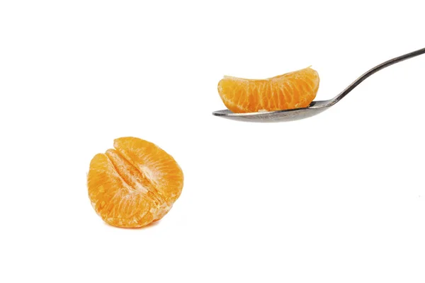 Una cuchara sostiene una rebanada de mandarina sobre un fondo blanco — Foto de Stock