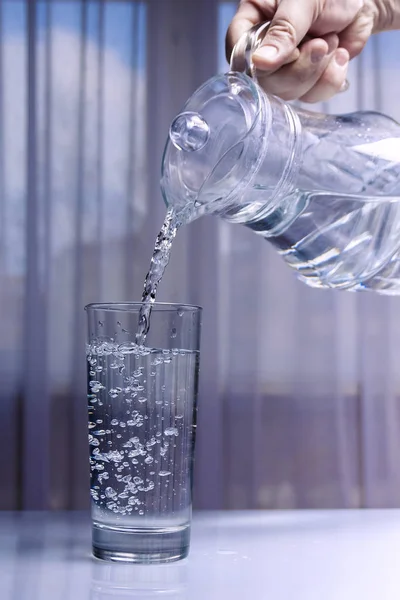 Su bir cam dekantör bir bardağa dökülür. Açık arka plan üniforma lı değil arka plan