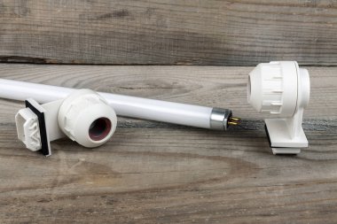 Yedek parça ile sökülmüş lamba ahşap bir arka plan üzerinde yatıyor