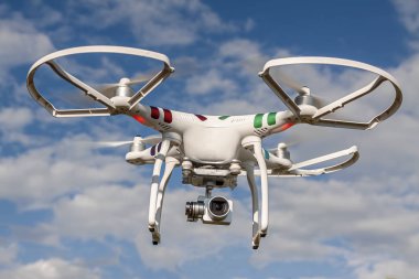 Quadrocopter mavi gökyüzüne karşı uçuş bir kamera ile.