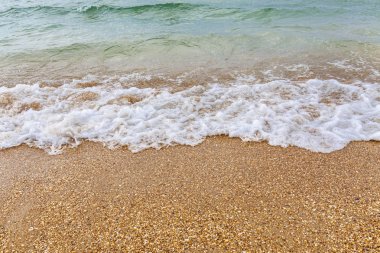 Kumlu kıyıda bir koşu dalgası.