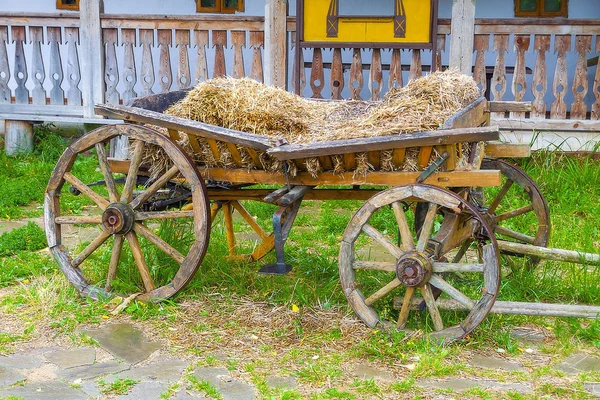 Old, broken, abandoned, cart with hay. Close-up.