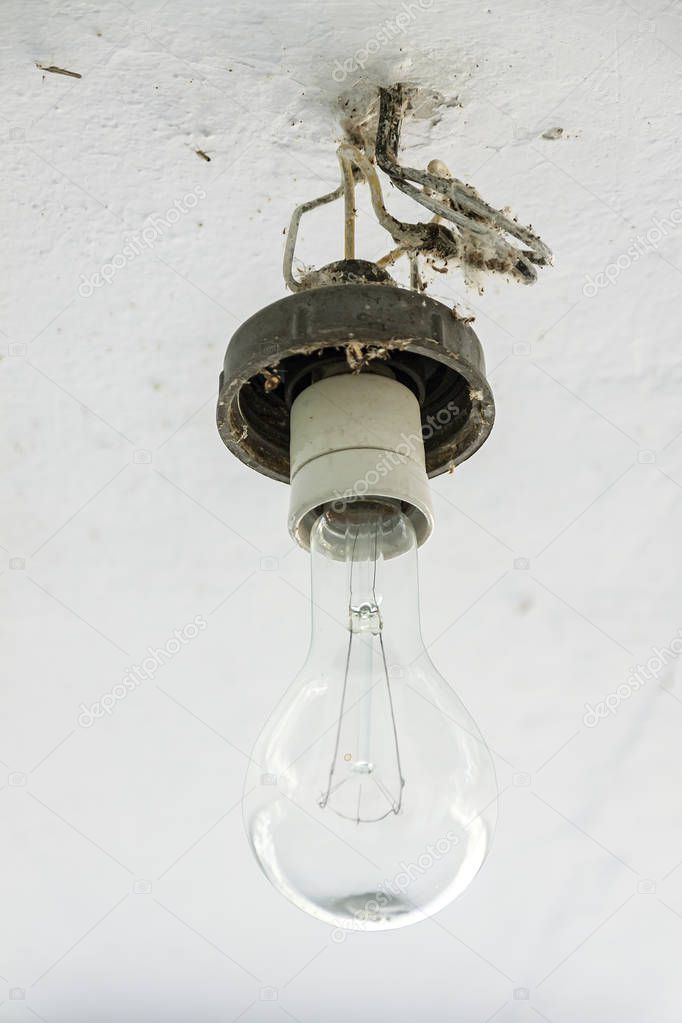 An old large incandescent lamp hangs on the ceiling.
