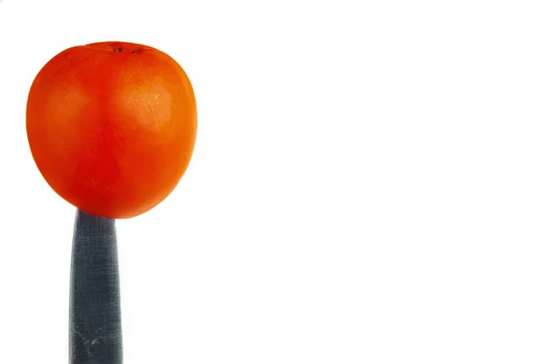 Tomat planterade på en kniv på en vit bakgrund. — Stockfoto