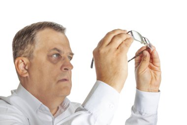 Bir adam gözlüklerinin saflığını kontrol eder.