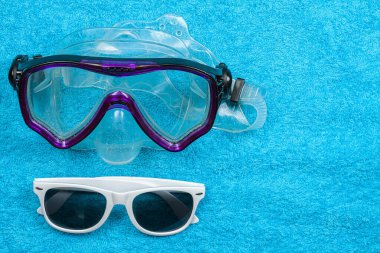 Dalış maskesi, güneş gözlüğü havlunun üzerinde.