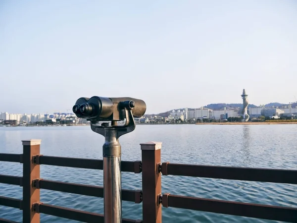 Observation binoculars on the pier and Sokcho city on the background, South Korea