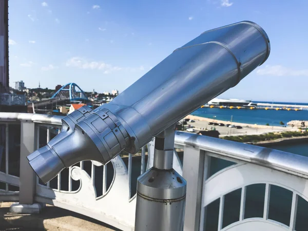 Observation binoculars on the bridge and Sokcho city on the background, South Korea