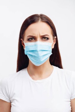 Tek kullanımlık maske takan esmer kadın gözleriyle duyguları gösteriyor.