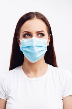 Tek kullanımlık maske takan esmer kadın gözleriyle duyguları gösteriyor.