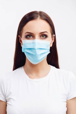 Tek kullanımlık maske takan esmer kadın gözleriyle duyguları gösteriyor.