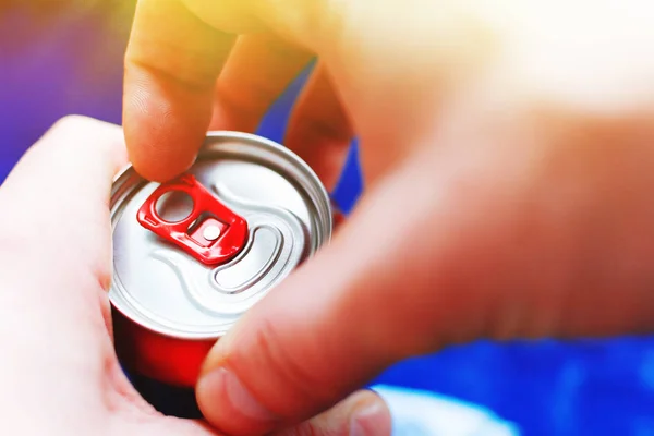 a man is going to open an aluminum can of beer, close-up