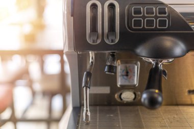 Kahve makinesinin kapatılması kahve dükkanında sabah saatlerinde güneş ışığı etkisiyle. kahve makinesinin len bulanıklık etkisi odağı