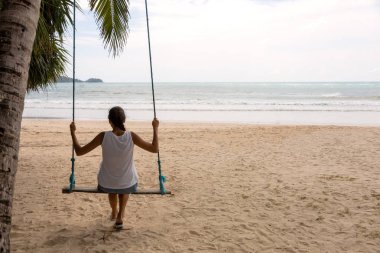 sahilde salıncak relex oturan kadın gezgin. kadın turist tatil saatinde deniz manzarası ile tadını çıkarın. Asya Tayland. Metin veya tasarım için kopyalama alanı ile