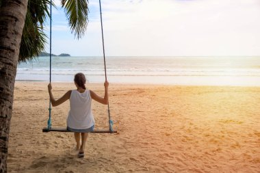 sahilde salıncak relex oturan kadın gezgin. kadın turist tatil saatinde deniz manzarası ile tadını çıkarın. Asya Tayland. Metin veya tasarım için kopyalama alanı ile