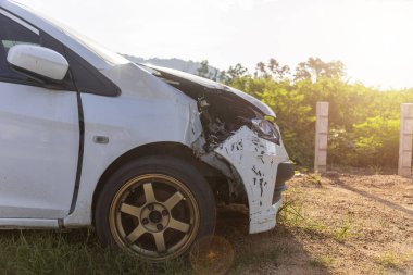 Beyaz renkli araba ön hasarlı ve yolda kaza parkı tarafından kırık artık sürücü olamaz.