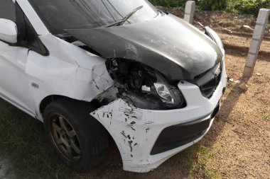 Beyaz renkli araba ön hasarlı ve yolda kaza parkı tarafından kırık artık sürücü olamaz.