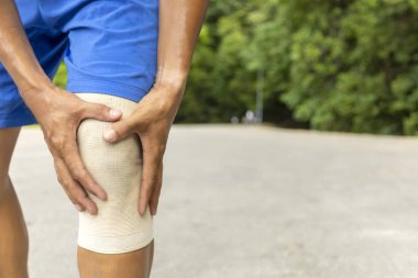 Mavi koşu şortlu adam metin veya tasarım için kopya alanı ile sabah saatlerinde yolda koştuktan sonra ellerini diz üzerinde tutun kullanın