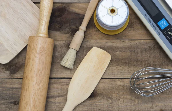 Back- und Kochwerkzeuge mit Küchenzeituhr, Waage auf Holztisch — Stockfoto