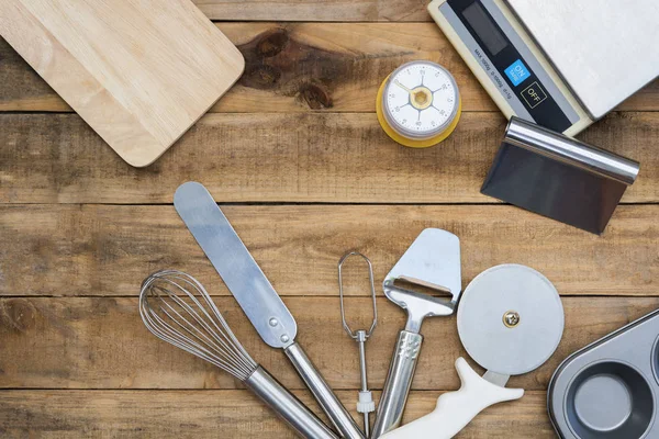 Back- und Kochwerkzeuge mit Küchenzeituhr, Waage auf Holztisch — Stockfoto