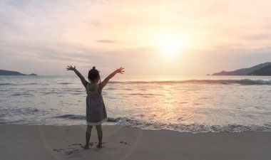 Çocuklar ellerini kaldırarak sahilde duruyorlar.