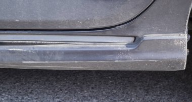 Araba kazası. yan etek koyu gri renkli araba yolda hasar çizik var. Scratch'ı kapat