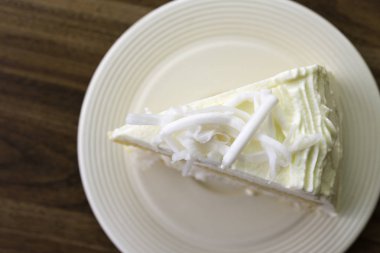 Beyaz çanak üzerinde hindistan cevizi kek bir parça