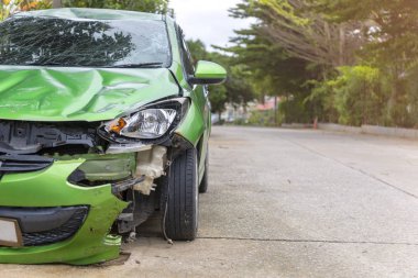 Yeşil renkli araba ön hasarlı ve yol park yerinde kaza ile kırık artık kirolamaz