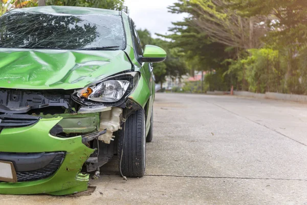 Frente de coche de color verde dañado y roto por accidente en el aparcamiento de la carretera no puede ensuciar más —  Fotos de Stock