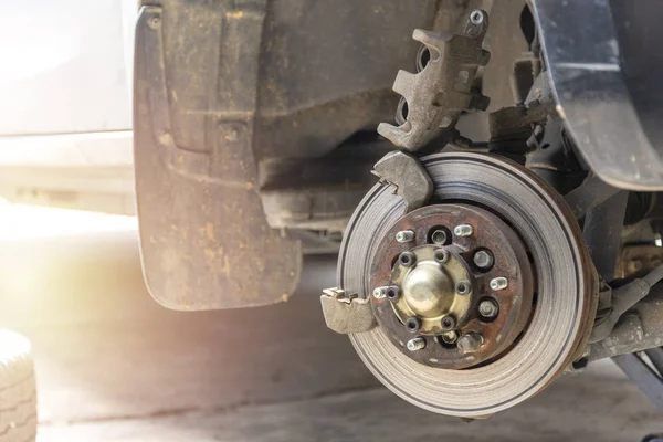 Front disc brake on car with brake caliper process of new tire replacement