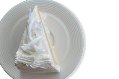 Üst görünüm beyaz arka plan üzerinde izole üstüne dilim Hindistan cevizi ile hindistan cevizi kremalı pasta kapatın. Kliple yol ile kaydet.