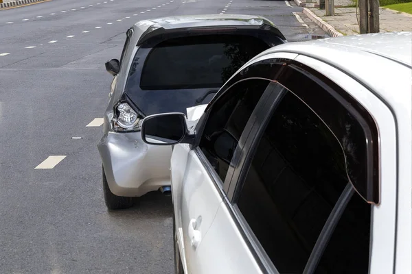 Frente de accidente de coche de color blanco con la parte posterior del coche de color negro dañado y roto por accidente en la carretera de la ciudad . — Foto de Stock