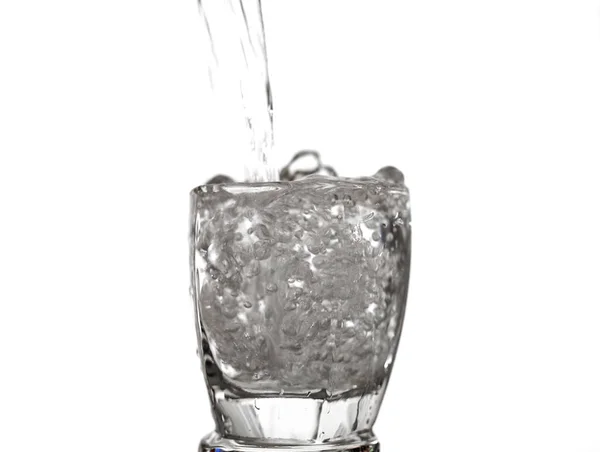 Spruzzi d'acqua a trabocco di vetro isolato su sfondo bianco — Foto Stock