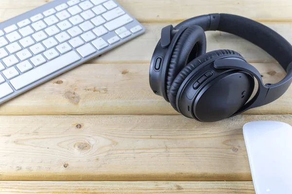 Headphones and laptop on wood table. With copy space for text or design. Technology concept.