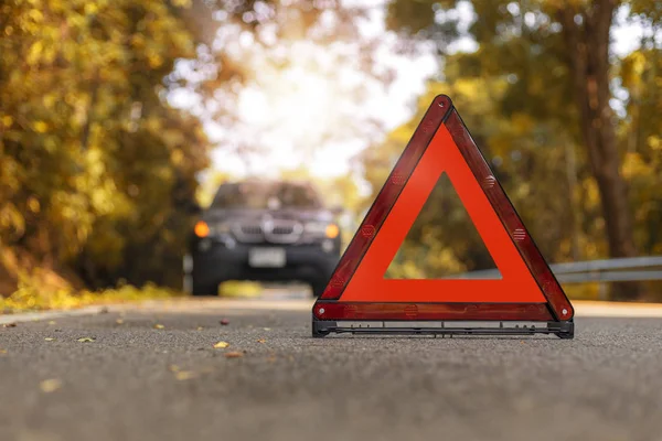 Красный треугольник, красный знак аварийной остановки, красный символ чрезвычайной ситуации и черный автомобиль остановки и парковки на дороге . — стоковое фото