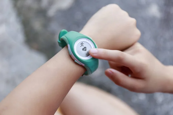 Close up Girl using smartwatch touching button and touchscreen on active sports. Finger touch button on smarth watch. Girl set smart watch before running on road.