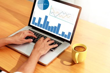 Bilgisayardaki istatistikleri analiz eden işadamı Hands bilgisayarını kullanarak online, iş ve finans grafikleri üzerinde çalışıyor.