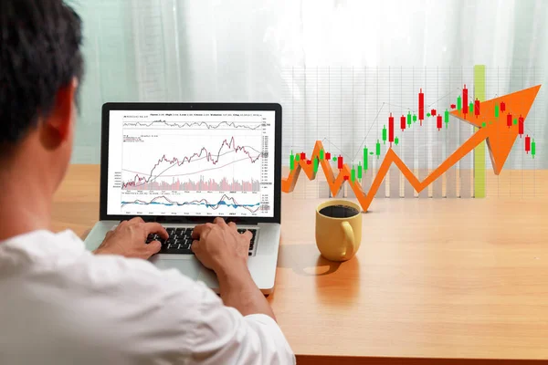 İş ve mali konsept Bişadamı dizüstü bilgisayar ticareti borsasını şamdan şeması ile kullanır. İşadamı bilgisayar ağı denetim ticareti kullanıyor. Borsa alıp satıyor.