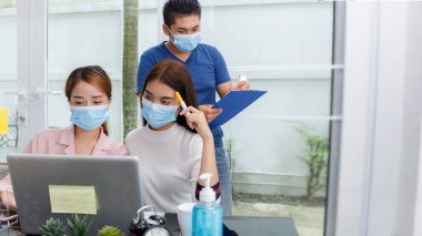 Asya İş Takımı Beyin Fırtınası Toplantısı. Coronavirus salgını arasında özel içişleri bürosunda sosyal mesafeler oluşturmaya başlayın. Yeni nesil iş adamları analizlerle bilgisayarda tanışıyor.