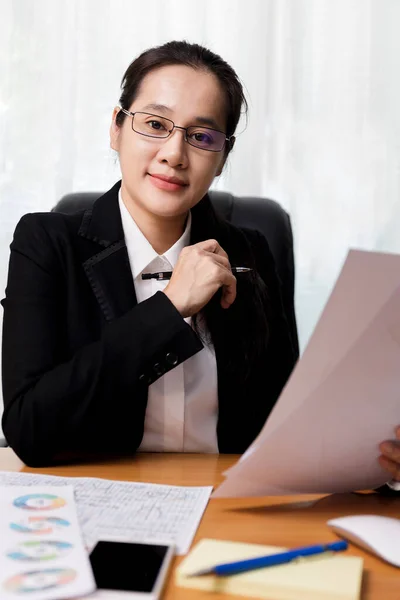 商业女性微笑着 戴着眼镜 手里拿着文件纸 坐在办公室里 在办公室使用电脑的商人 家庭企业概念 — 图库照片