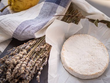 Tahta tabakta çeşitli peynir atıştırmalıkları ve beyaz tabakta salata.