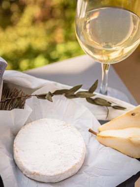 Tahta tabakta çeşitli peynir atıştırmalıkları ve beyaz tabakta salata.