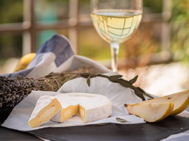 Tahta tabakta çeşitli peynir atıştırmalıkları ve beyaz tabakta salata.