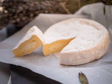 Tahta tabakta çeşitli peynir atıştırmalıkları ve beyaz tabakta salata.