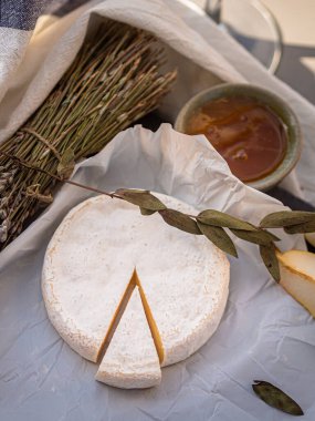 Tahta tabakta çeşitli peynir atıştırmalıkları ve beyaz tabakta salata.