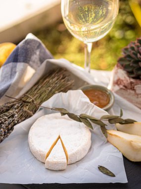 Tahta tabakta çeşitli peynir atıştırmalıkları ve beyaz tabakta salata.