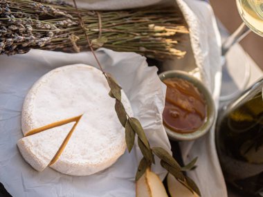 Tahta tabakta çeşitli peynir atıştırmalıkları ve beyaz tabakta salata.