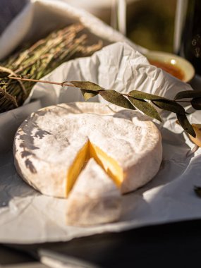 Tahta tabakta çeşitli peynir atıştırmalıkları ve beyaz tabakta salata.