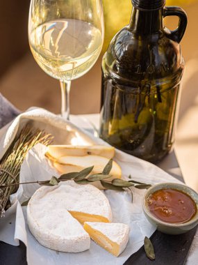 Tahta tabakta çeşitli peynir atıştırmalıkları ve beyaz tabakta salata.